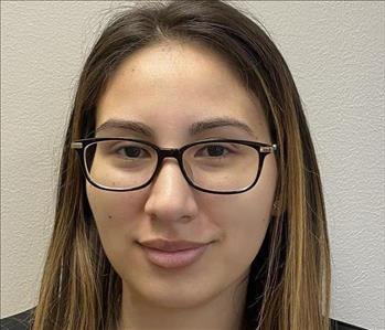 Female employee smiling in front of background 