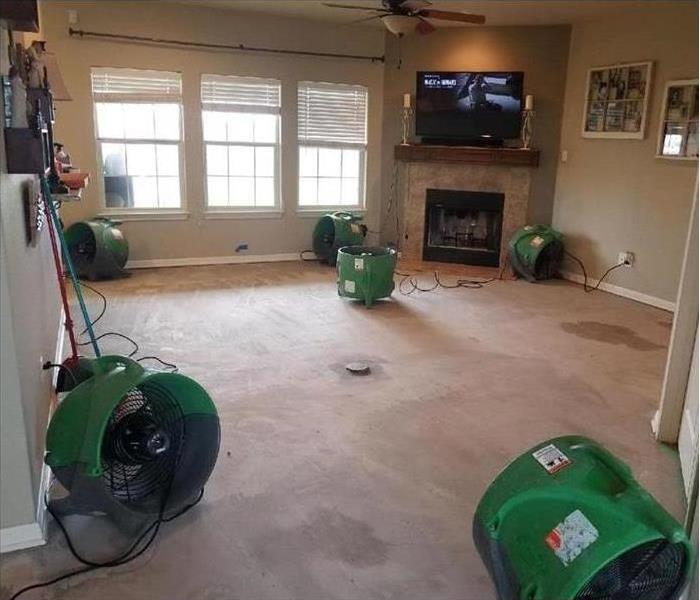 Equipment placed on empty living room to dry wet carpet and walls